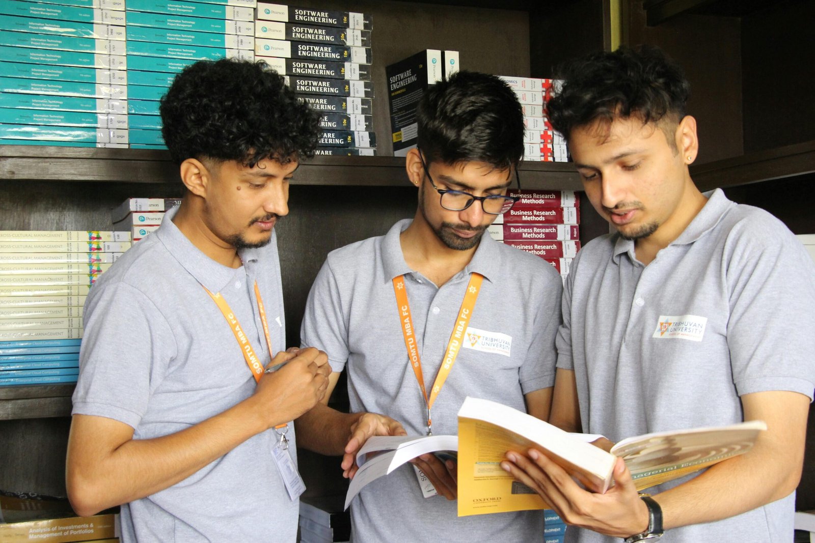 gas-pipeline Three male students studying in a library, focused on business books, at Nepal university.